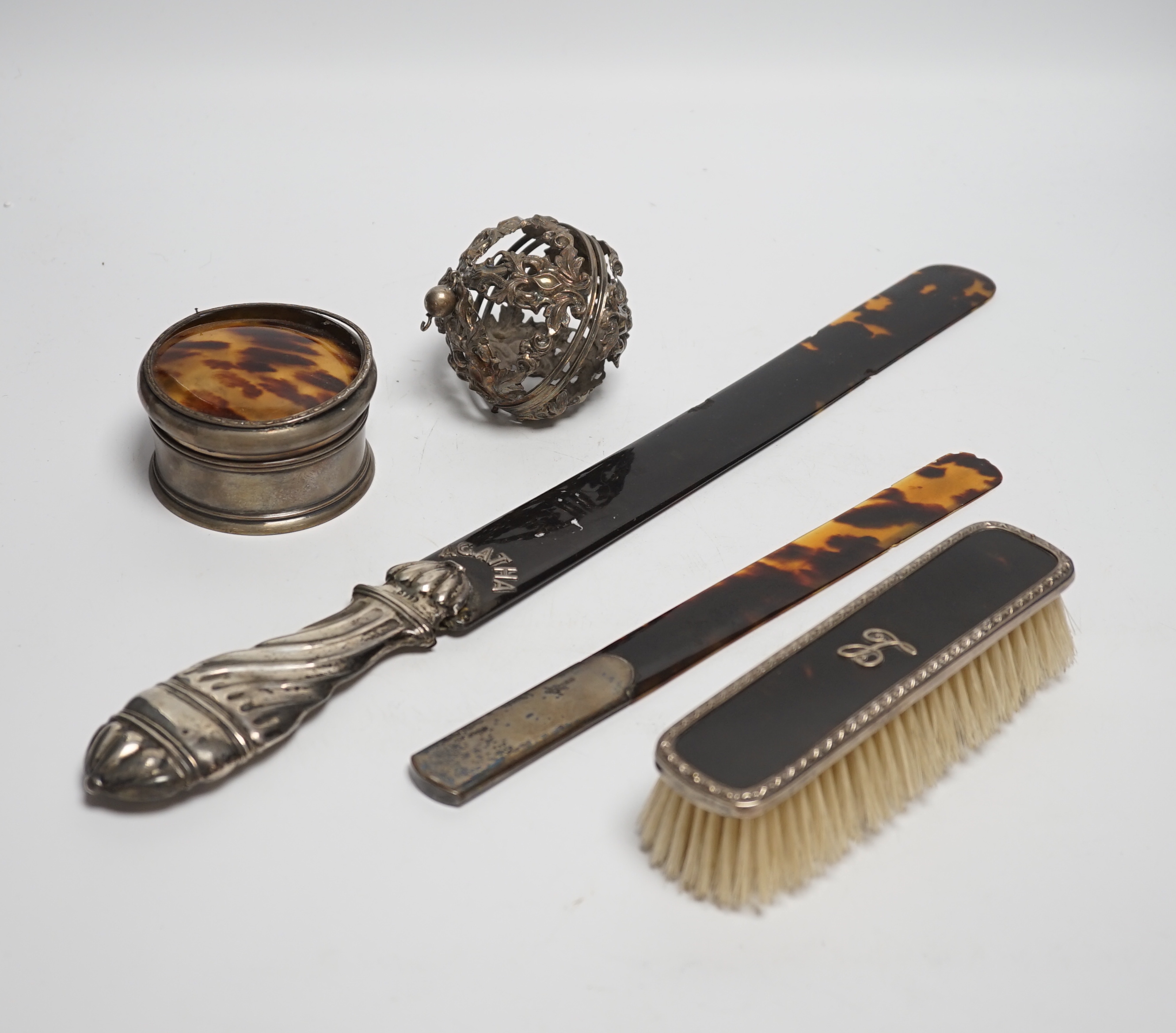 A late Victorian silver handled tortoiseshell page turner, a small page turner, a silver and tortoiseshell box and brush and a white metal pomander case.